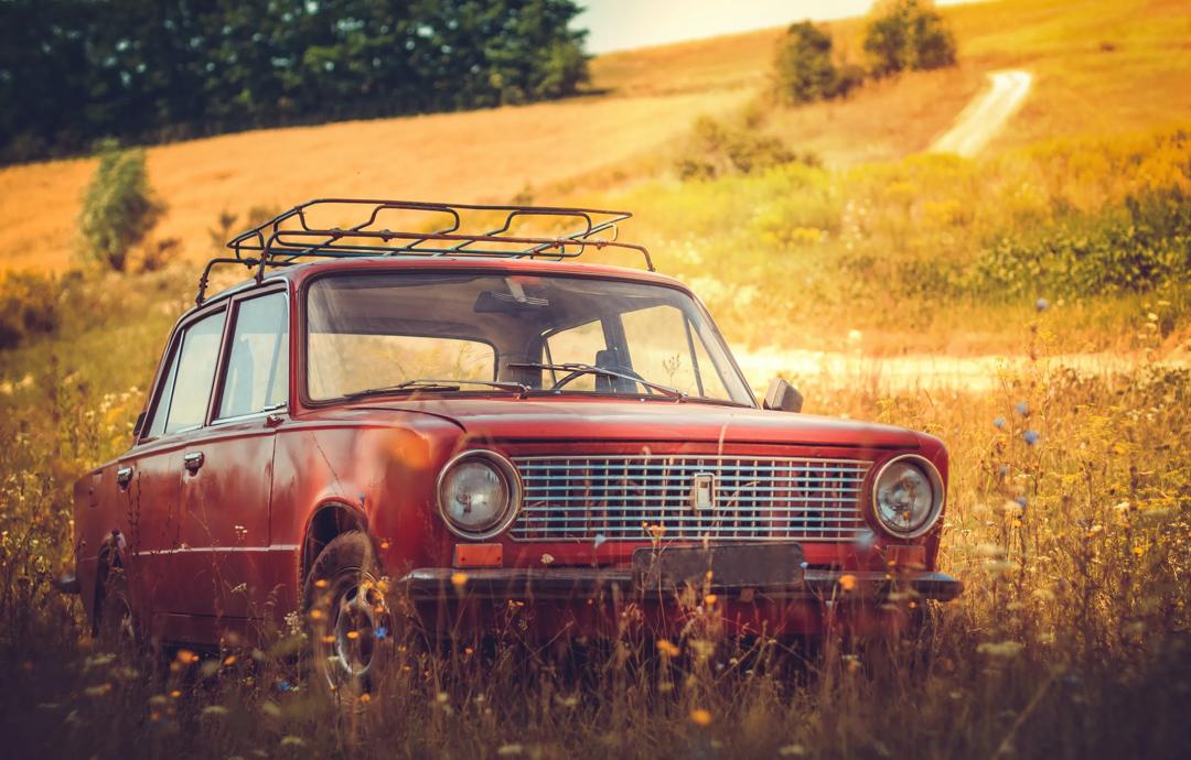1960-70-tallet var en tid da barn gjerne lå på bilens hattehylle og barneseter knapt nok var oppfunnet. Her en klassisk rød bil fra denne perioden. (Foto: The Nigmatic on Unsplash)
