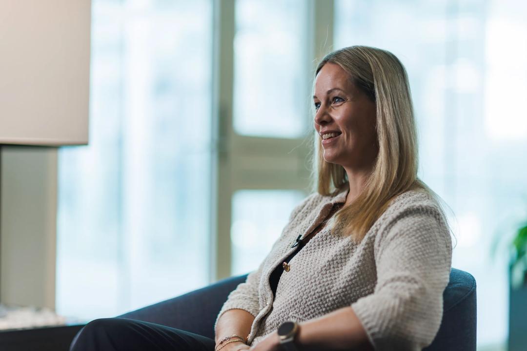 Camilla Sandbakken sitter i en stol i kontormiljø