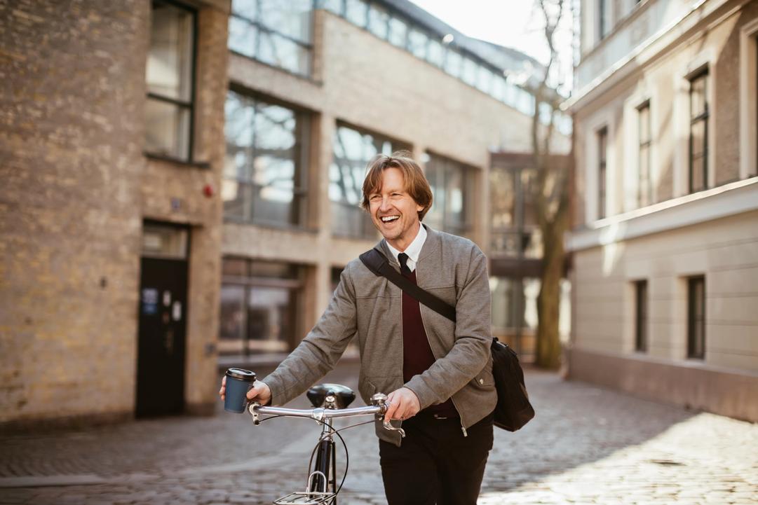 A happy man walking with his Caroline bicycle