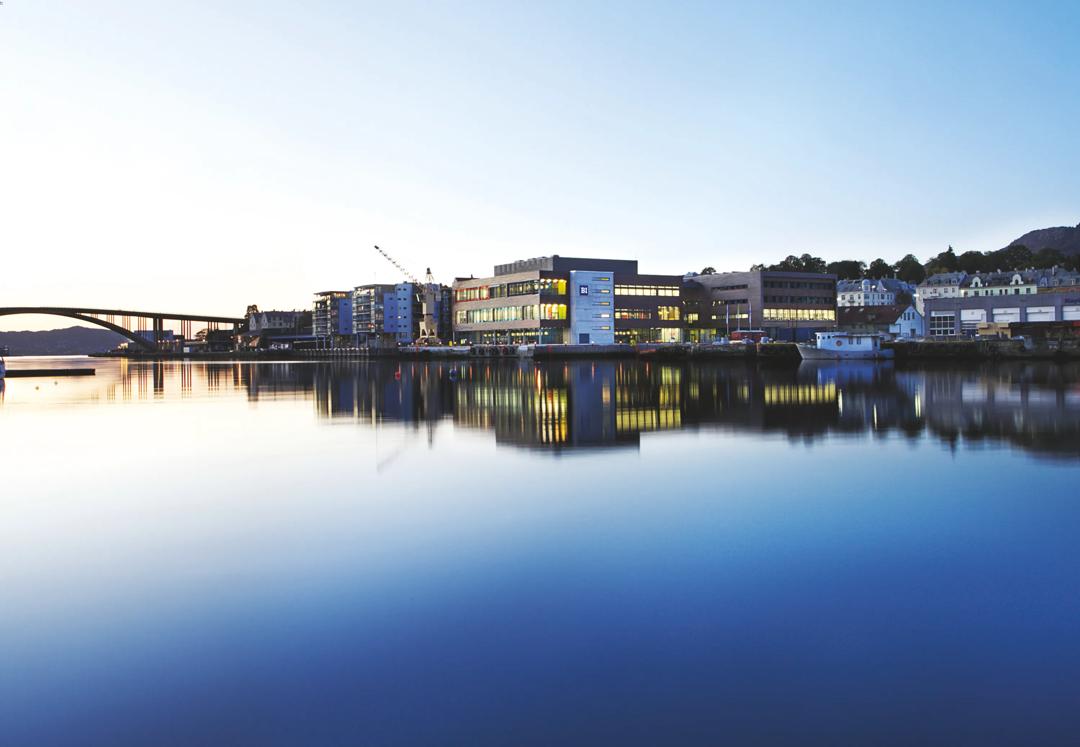 Utenfor campus Bergen. Bilde av vannet og en bro, med BI-bygget i midten.