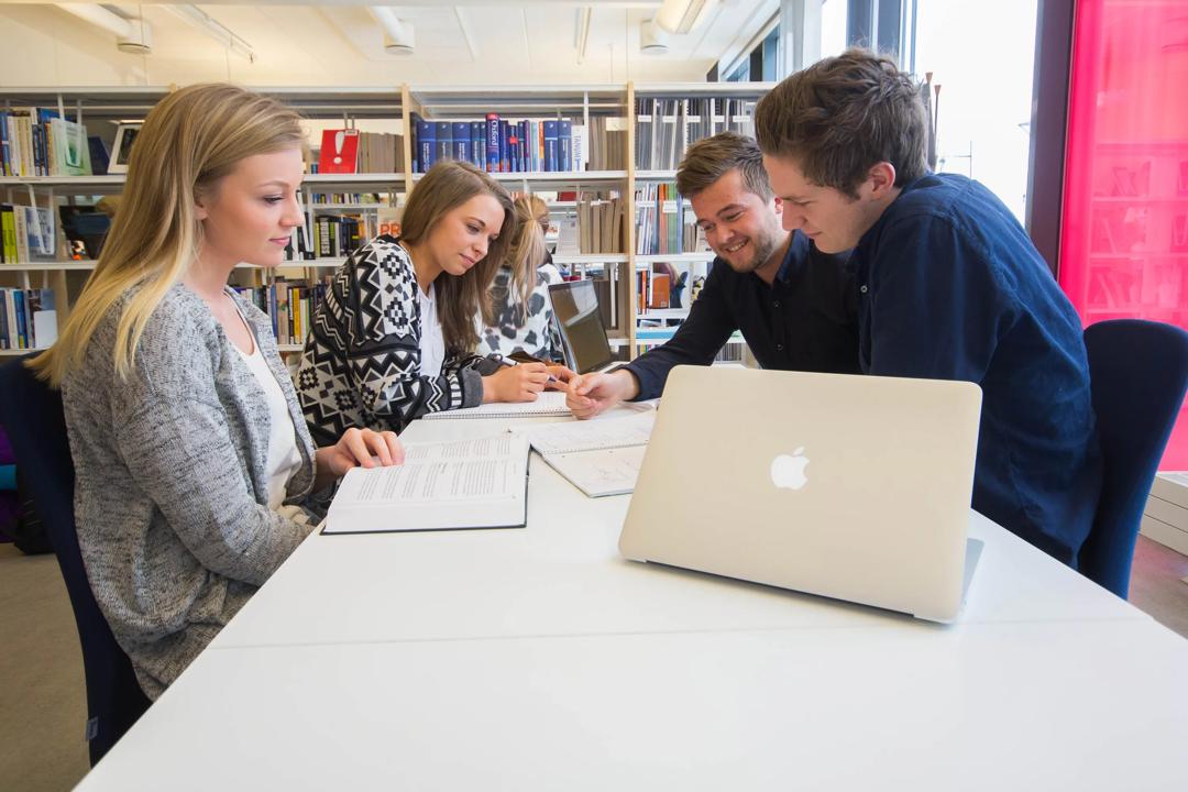 Studenter som sitter å jobber sammen på biblioteket