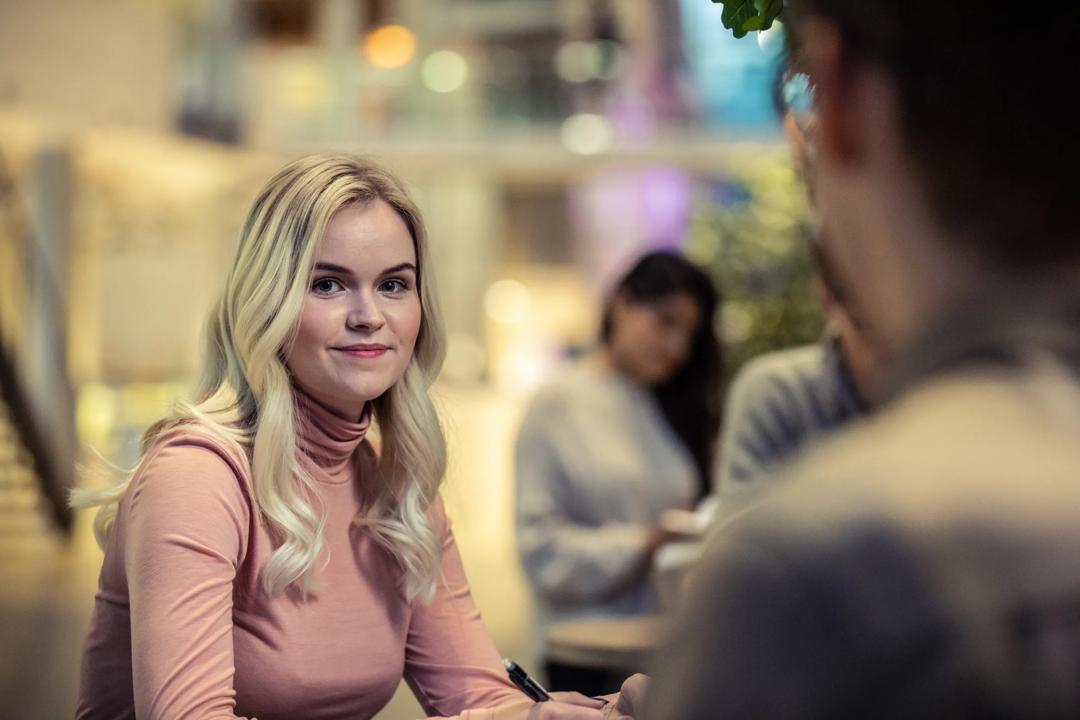 Bilde av ei blond kvinne på campus