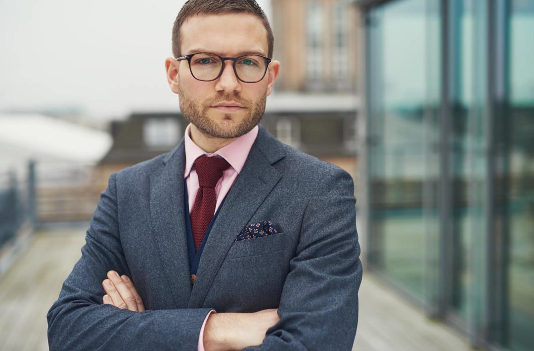 Confident businessman standing outside office