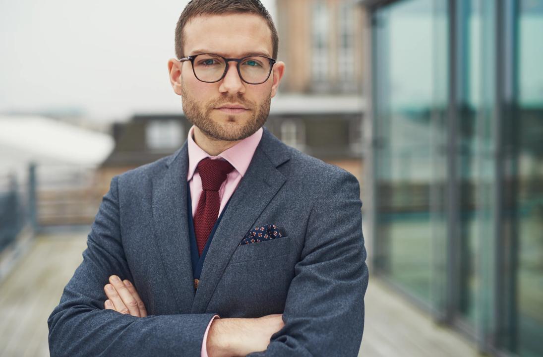 Confident businessman standing outside office