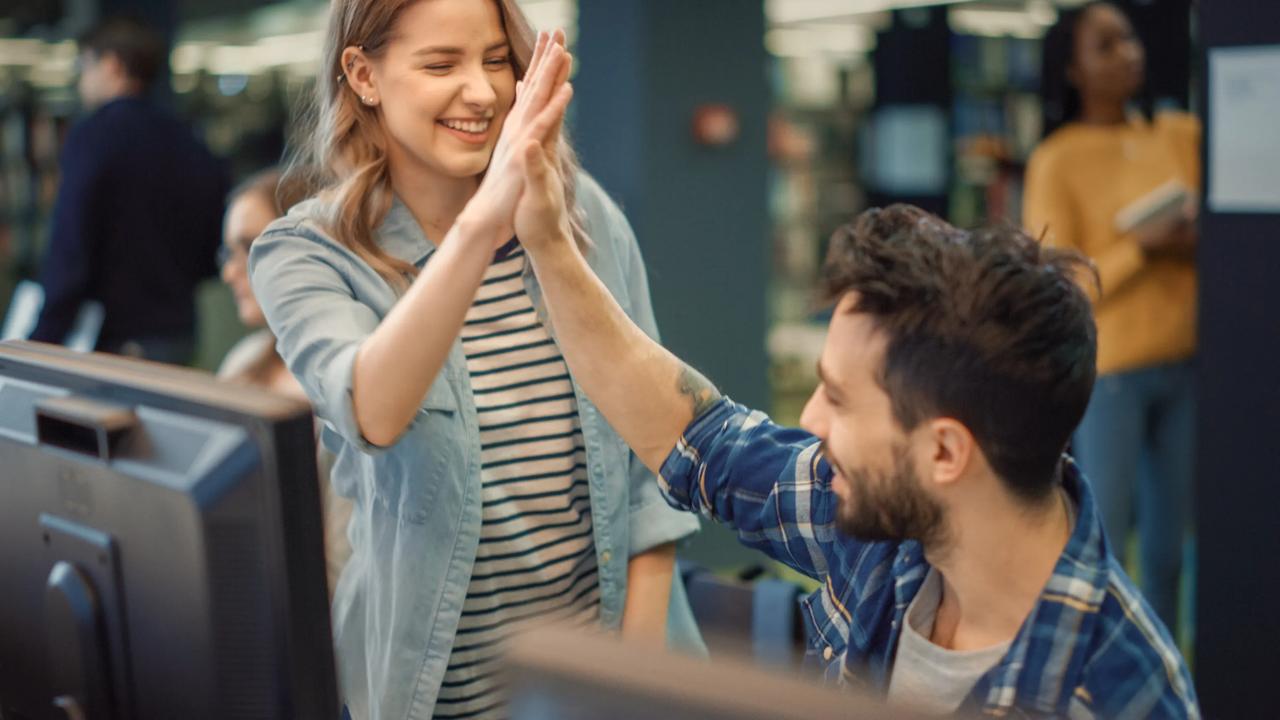 A woman and a man giving a high five too each other