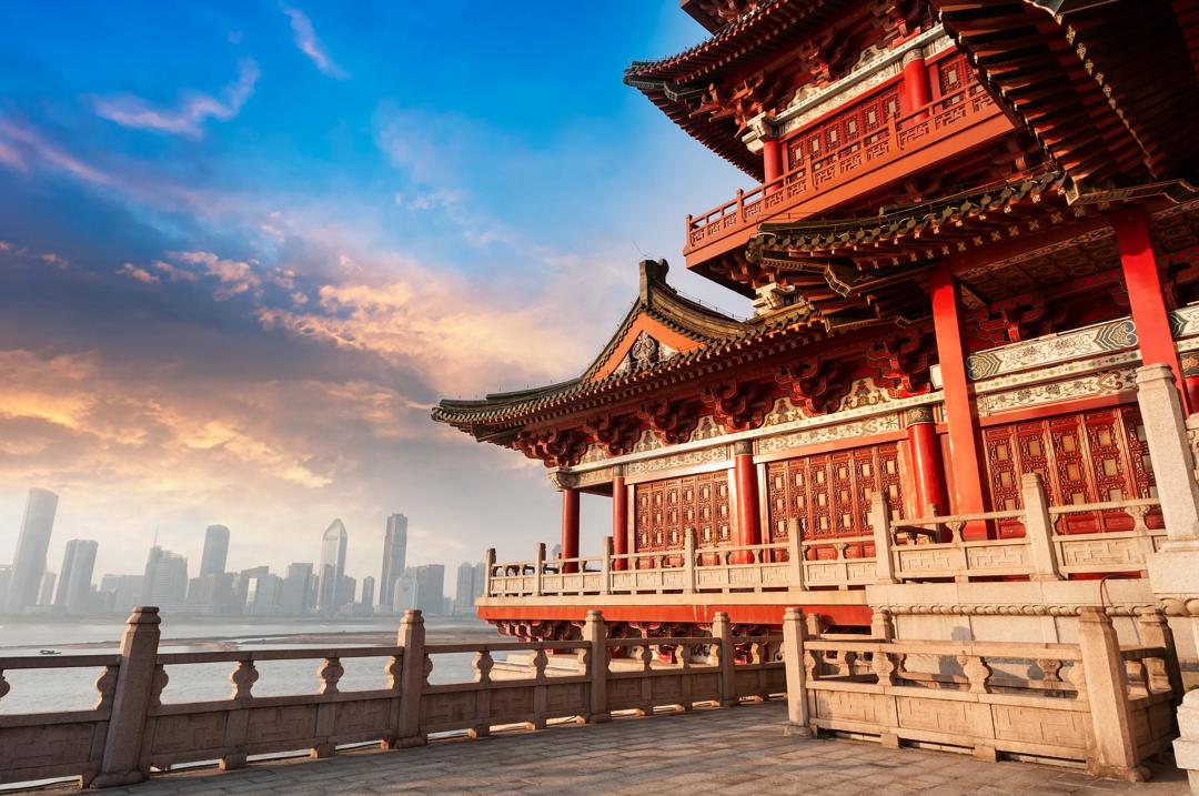 Image from China showing a classical Chinese building in the foreground and a cityscape of skyscrapers in the background.