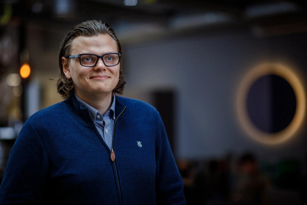 Bilde av en smilende mann som ser fremover