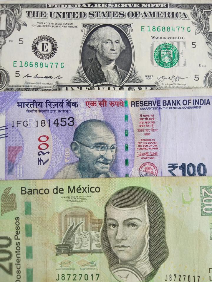 A dollar bill, a rupee bill and a peso bill
