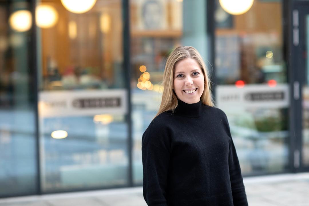 En kvinnelig student som smiler til kamera