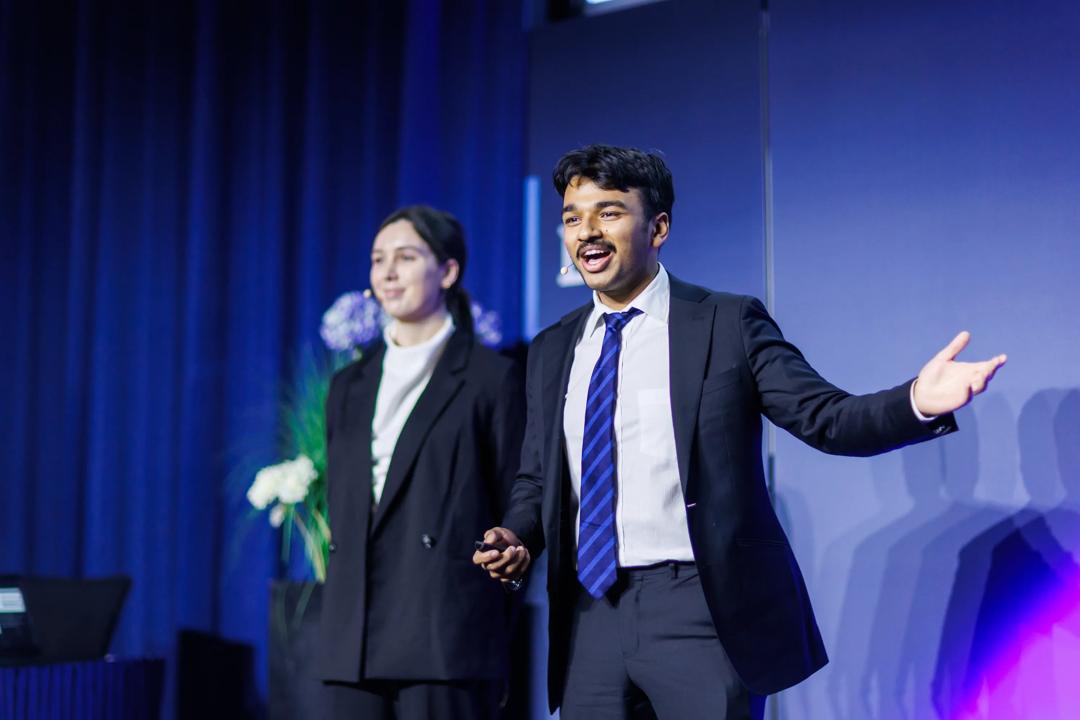BIICC 2025. A male student presenting in front of the jury.