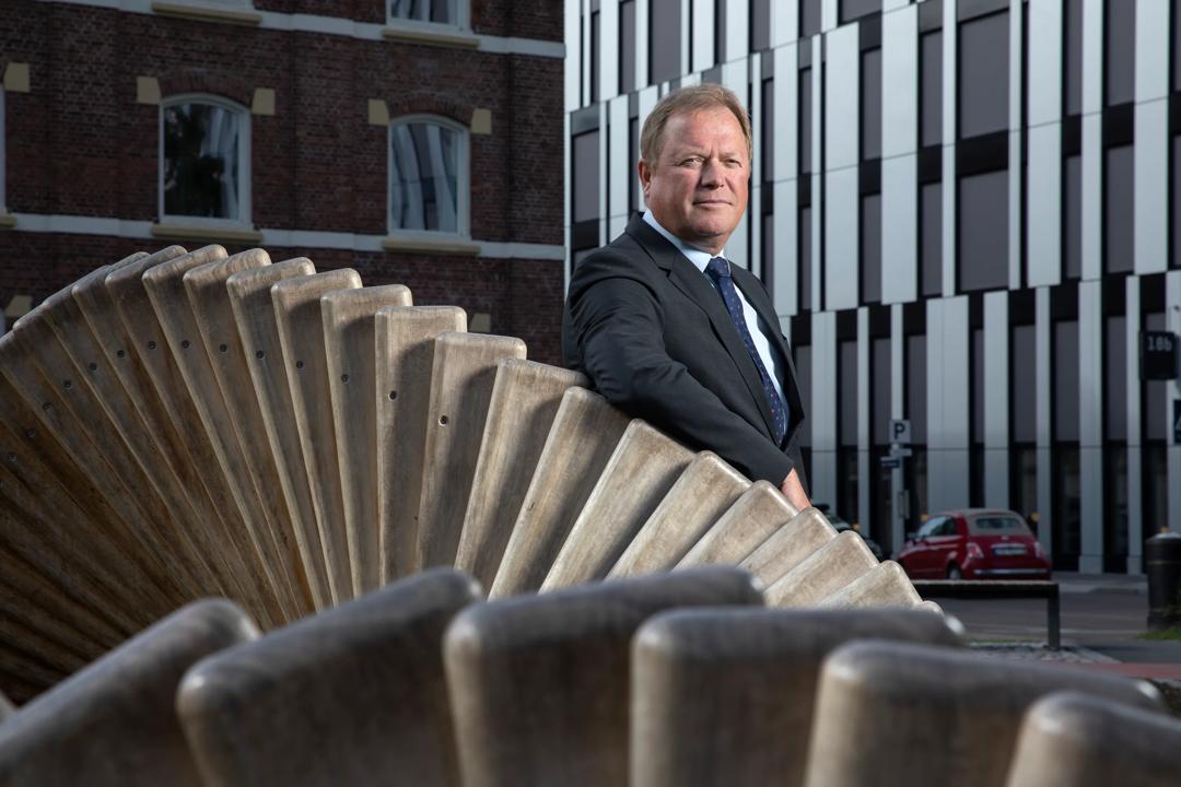 Rektor Inge Jan Henjesand som lener seg p&aring; en skulptur