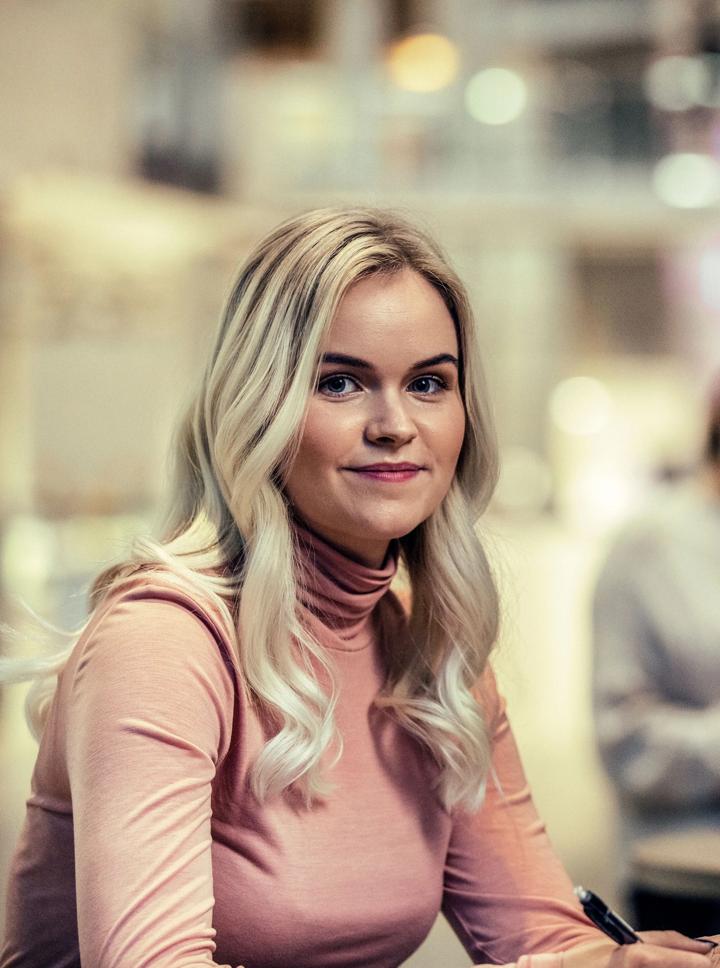 Bilde av ei blond kvinne på campus
