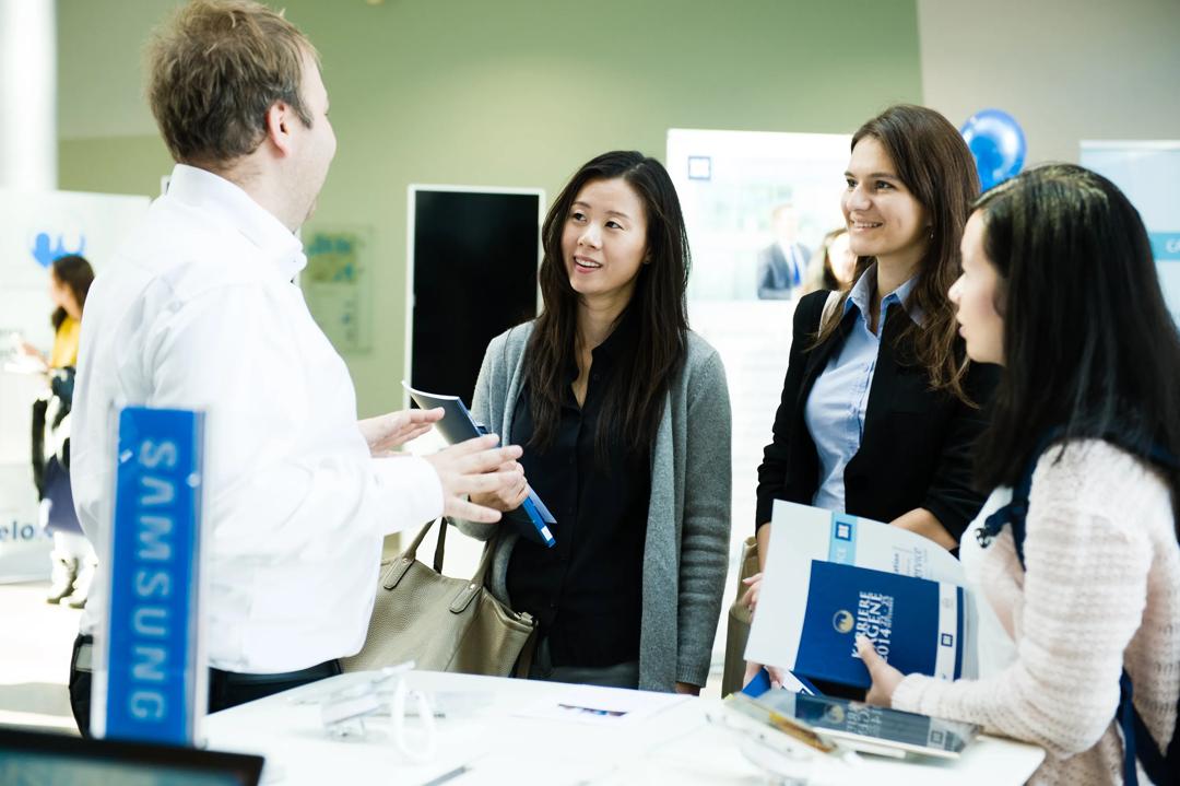 Students talking to a man at a stand during Karrieredagene