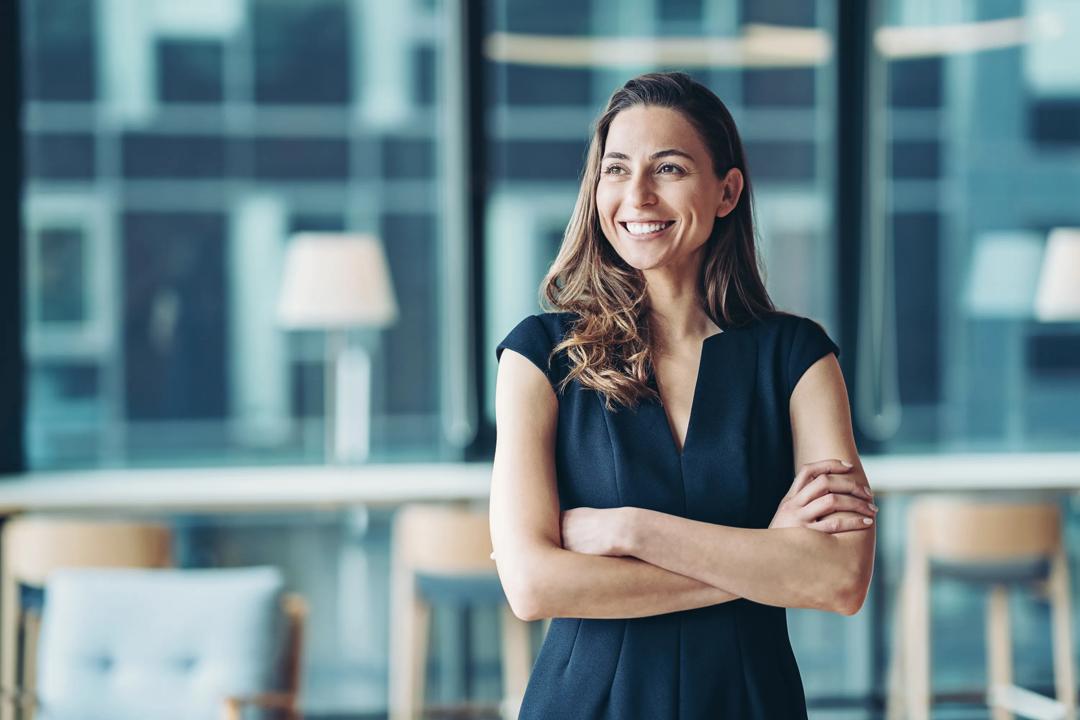 Smilende dame som holder hendene i kors