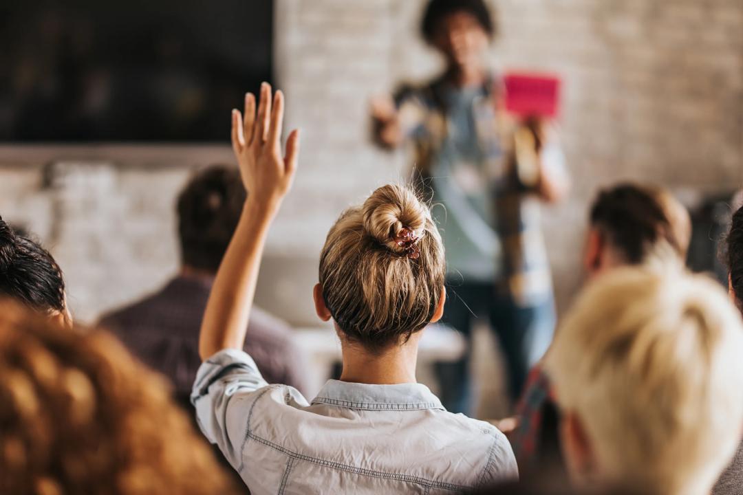 Woman raising her hand i a classroom