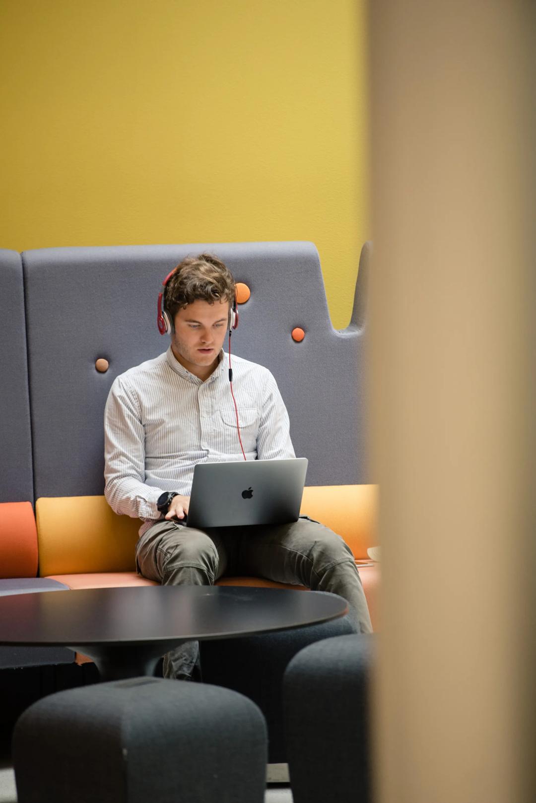 Young man with Mac and headphones