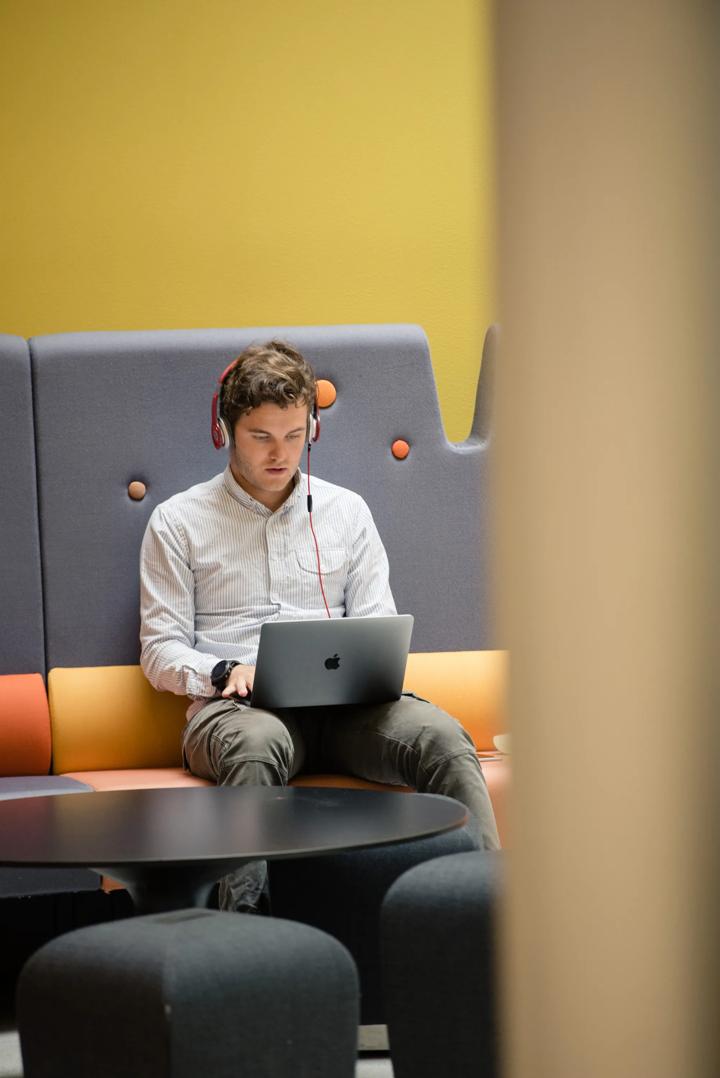 Young man with Mac and headphones