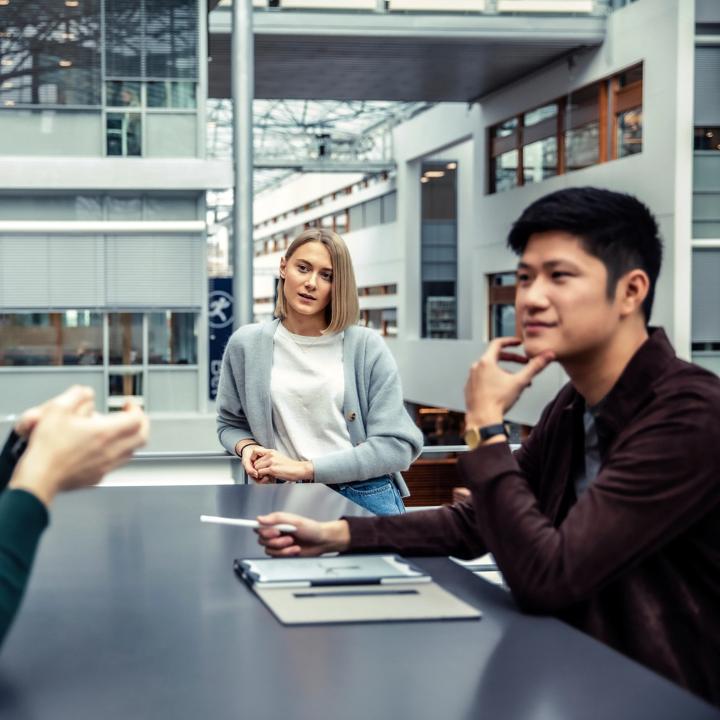 Tre studenter som sitter sammen