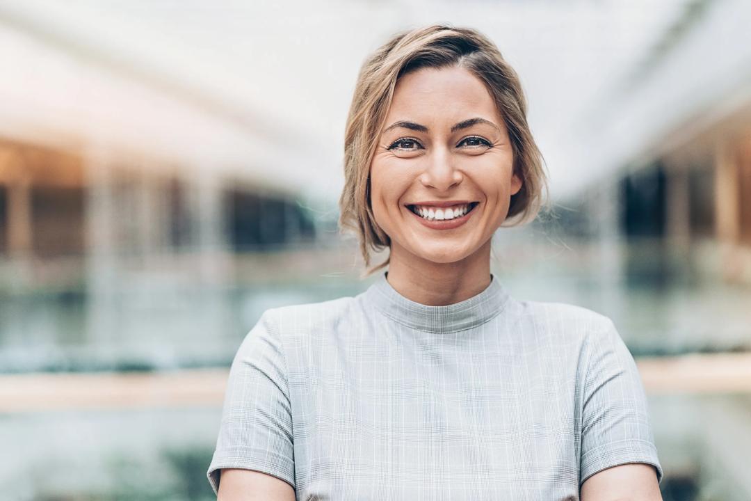 Bilde av stående, smilende kvinne