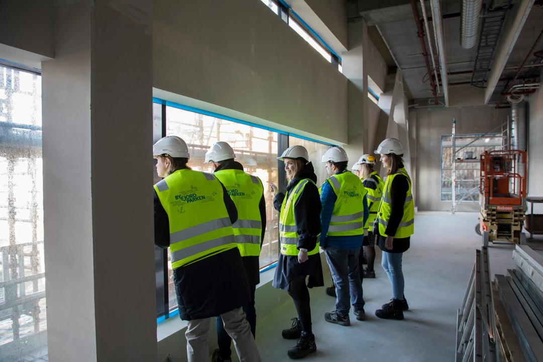 Bygningsarbeidere som ser ut av et bygg under konstruksjon