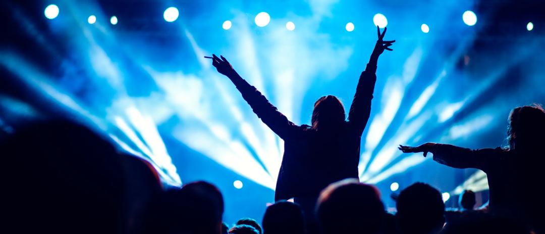 Person på konsert med armene over hodet