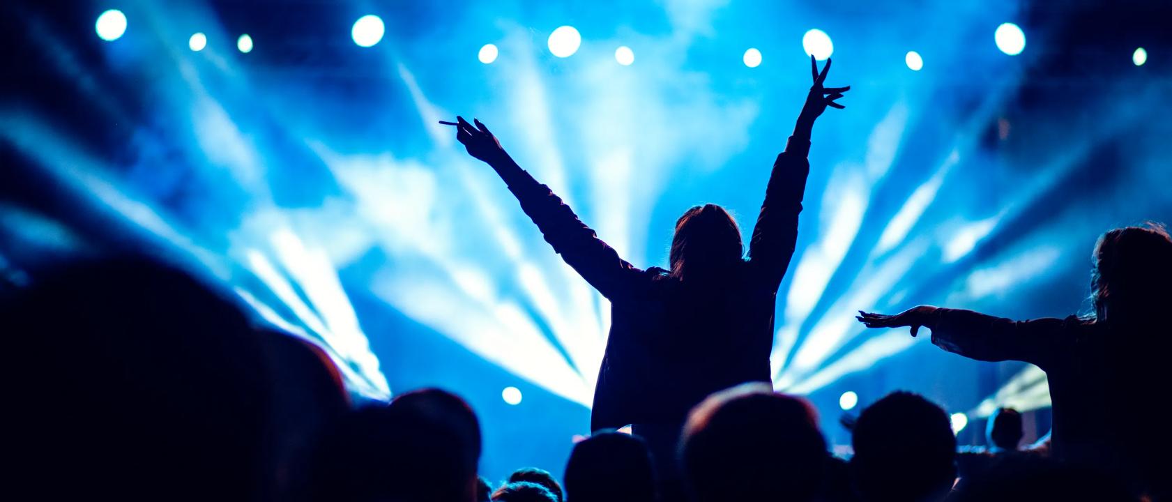 Person på konsert med armene over hodet