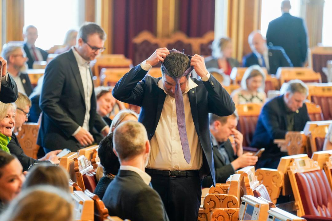Geir Pollestad tar på seg slipset før debatten om inntektsberegningen for landbruket i Stortingssalen i 2024