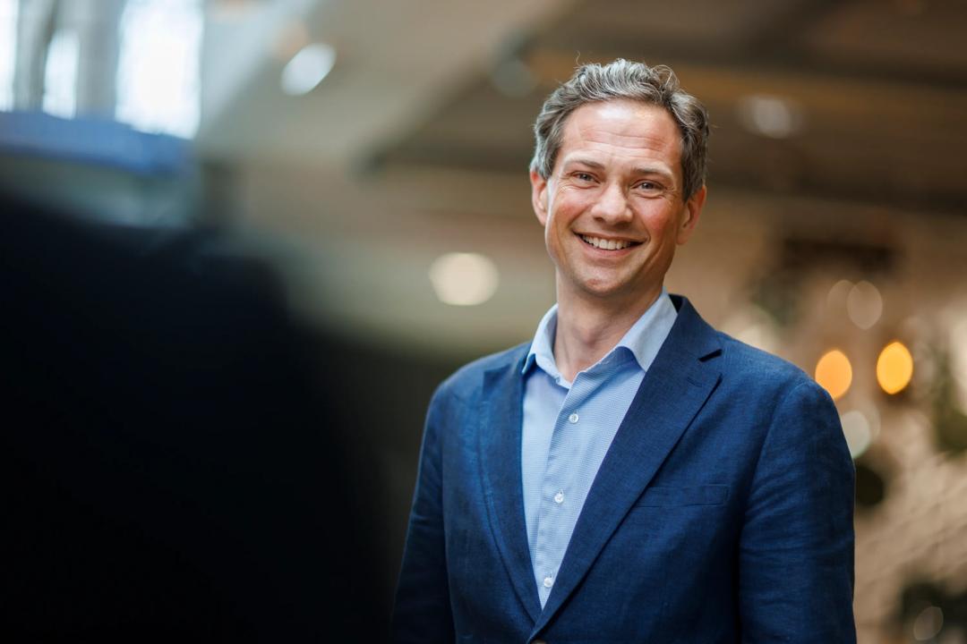 Bilde av stående, smilende mann