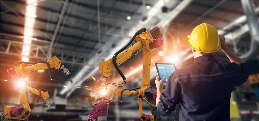 En arbeider som jobber med en robot