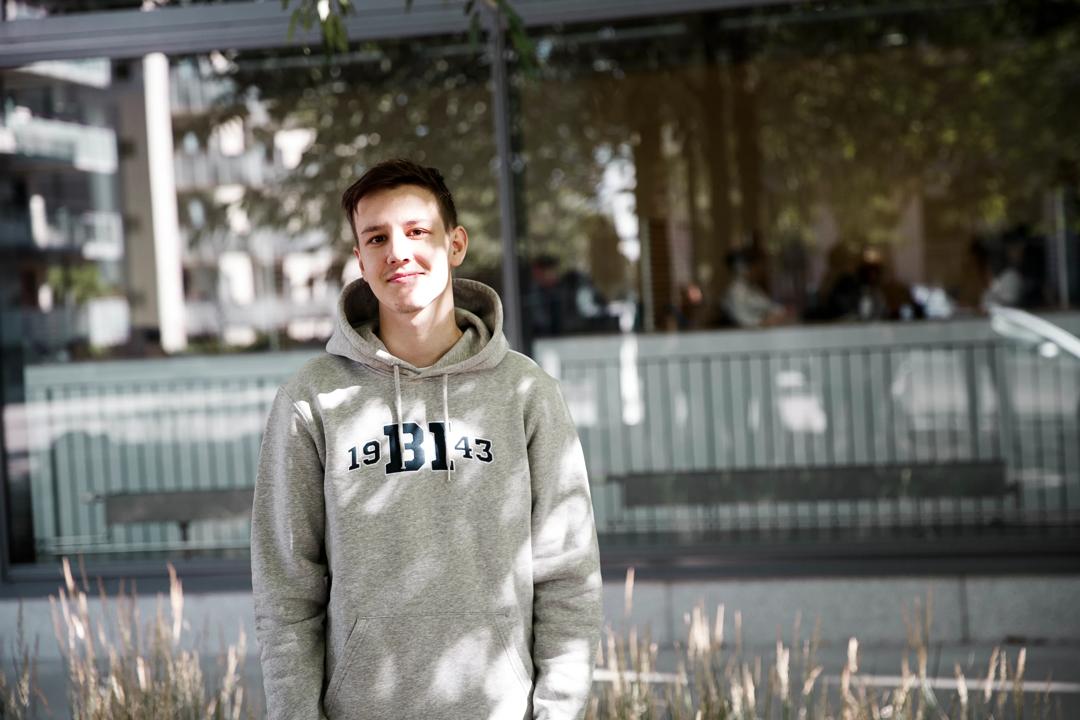 Smilende mann i grå BI-genser