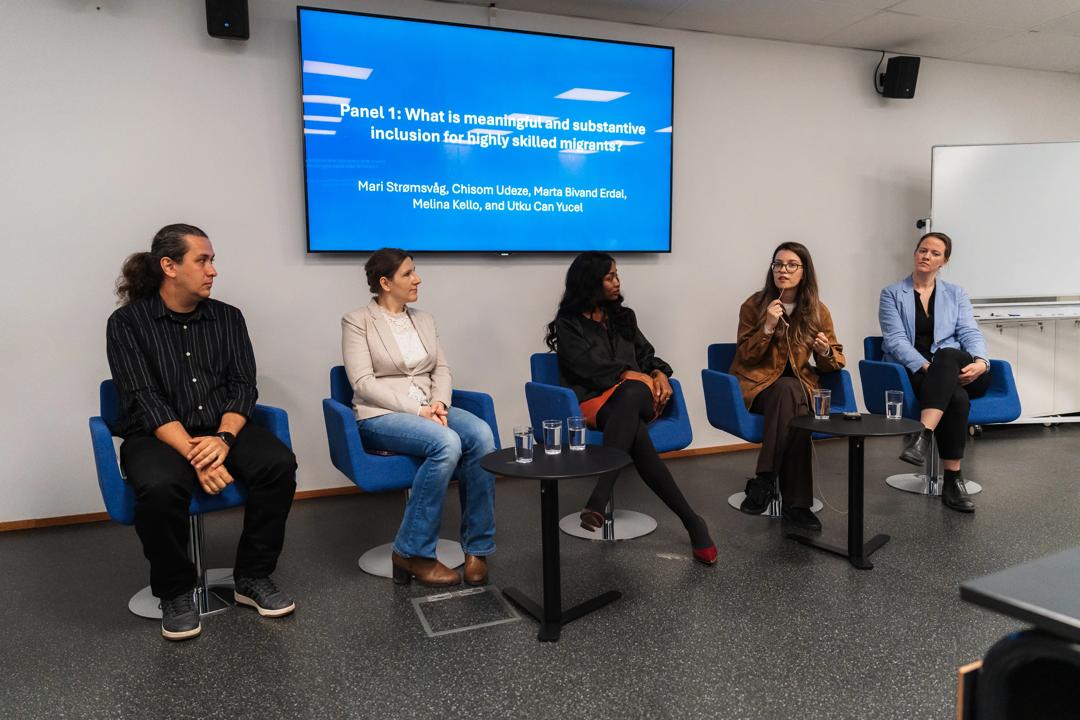 Image of the panel discussion. Five people sitting and debating