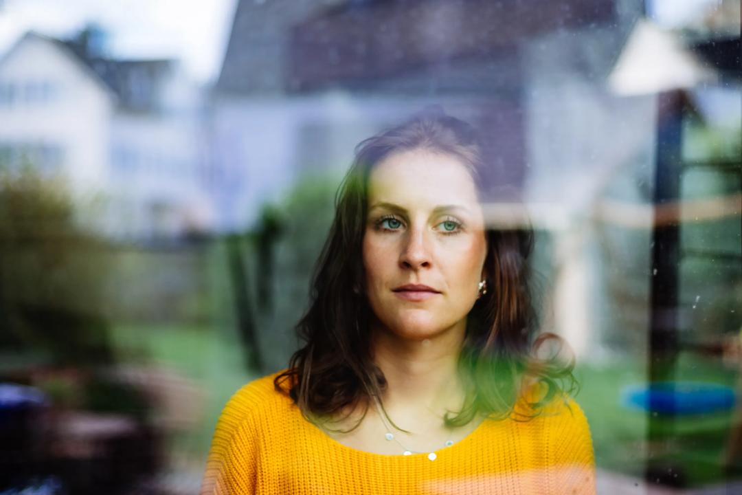 Woman looks thoughtfully through the window.