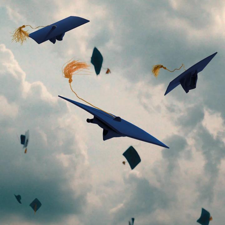 Feiring av fullført BI-studium: graduasjonshatter i luften. – symbol på nye muligheter.