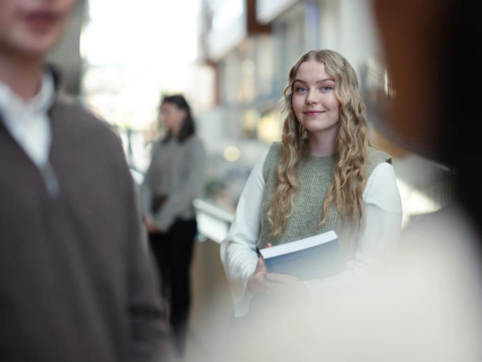 Kvinnelig student med bøker i hånda