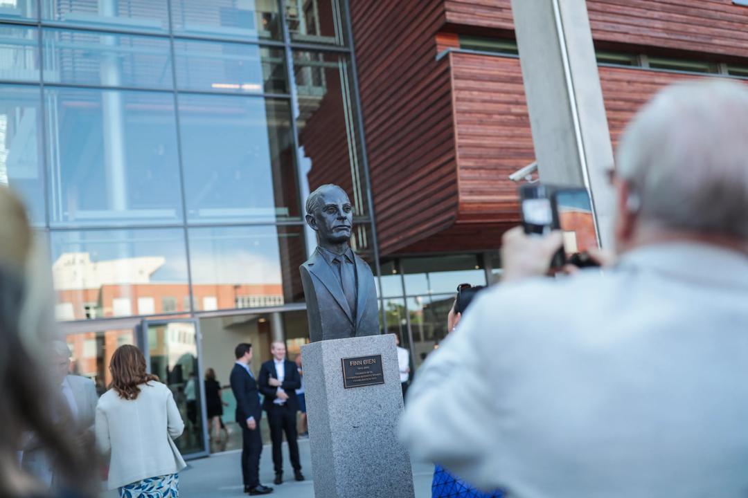 Outside of campus Oslo, with a statue of Finn Øien in front