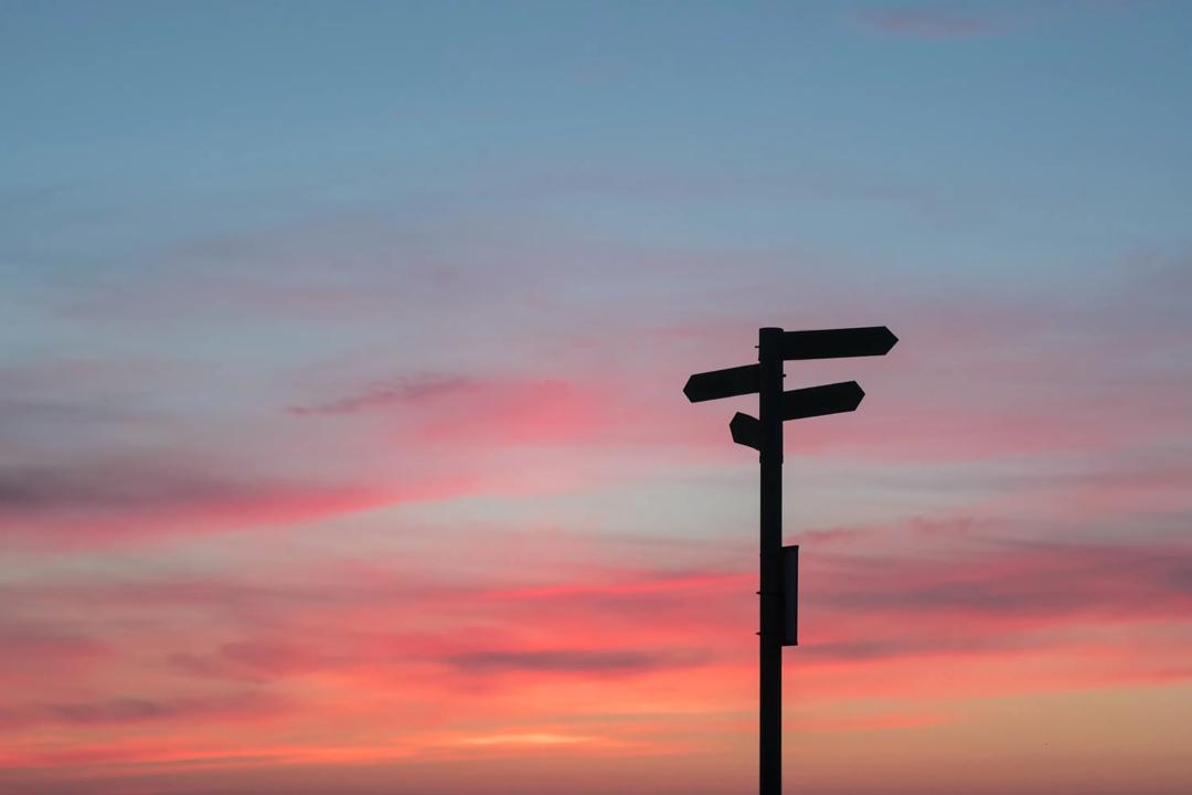 Bilde av et skilt i siluett som viser ulike retninger. (Foto:  Javier Allegue Barros on Unsplash).