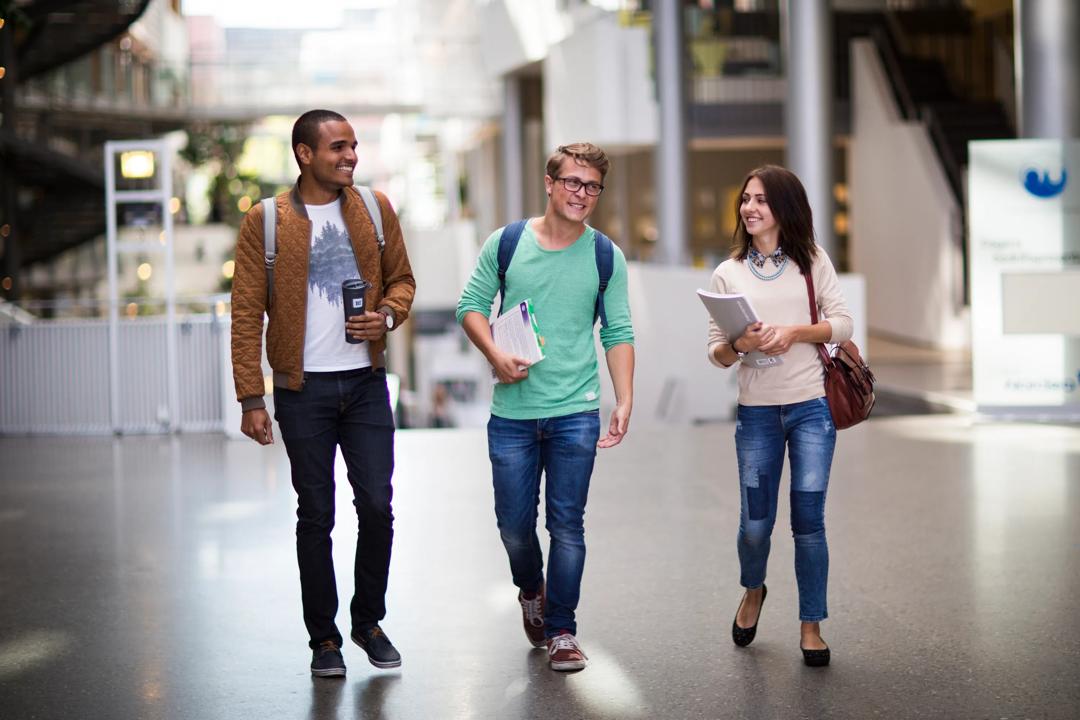 Smilende studenter som går gjennom campus Oslo