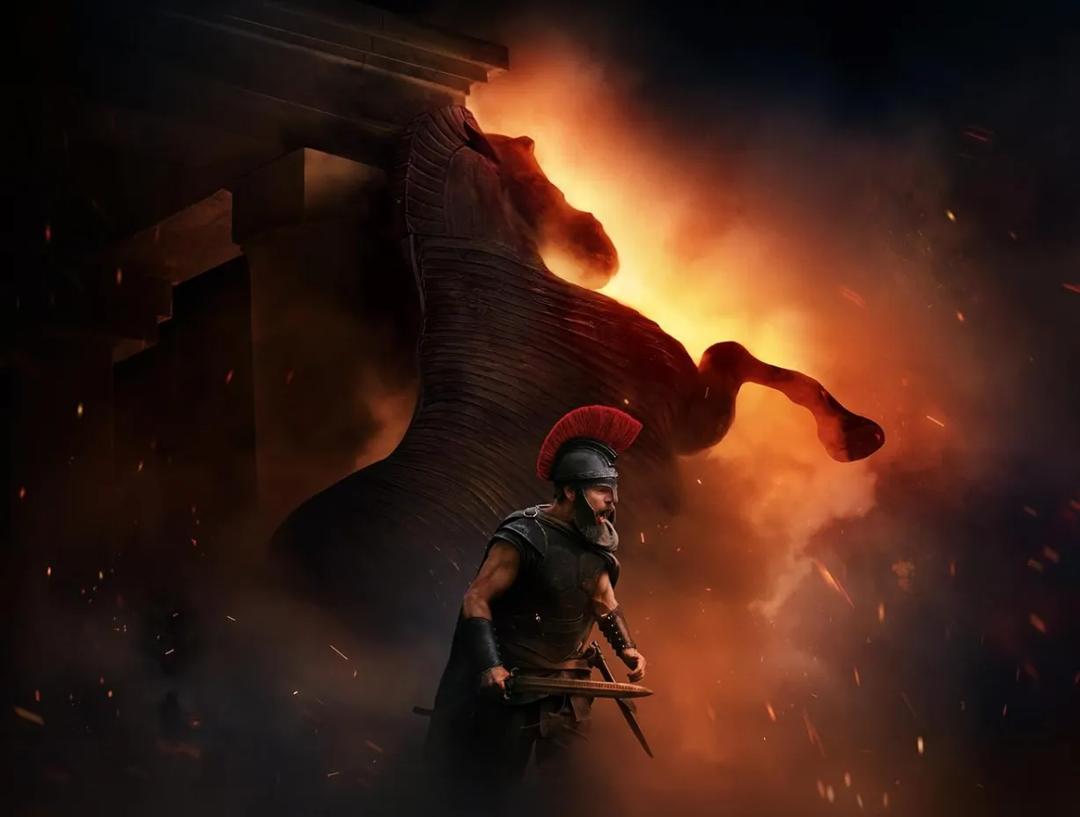Bilde fra filmen The Odyssey med skuespilleren Matt Damon i fokus. I bakgrunnen er det en hest og flammer.