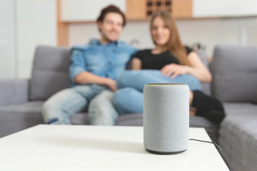 Smart speaker on a table in front of a couble in a sofa