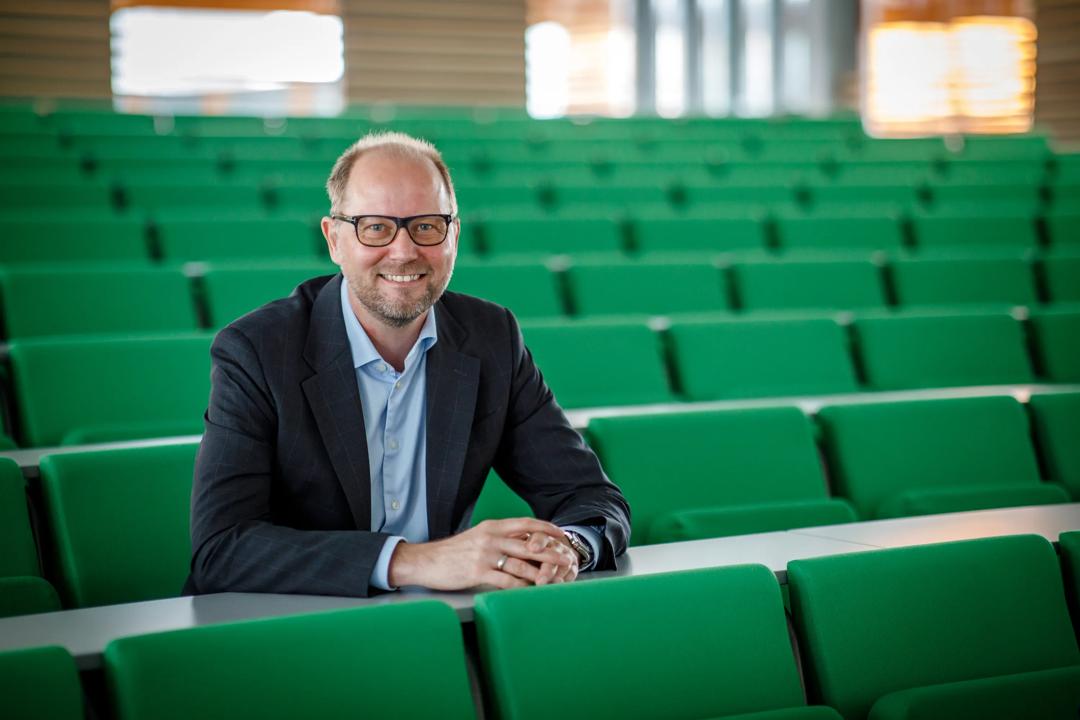 Professor Bjørn Erik Mørk sittende i et auditorium
