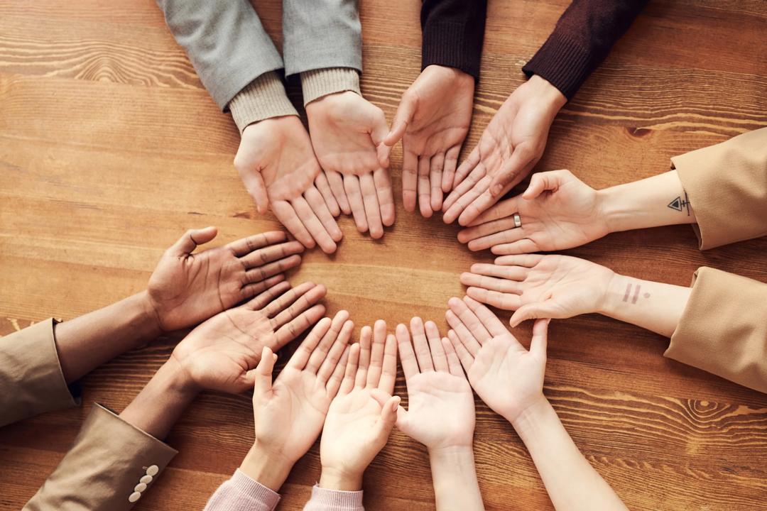 hoto Of People's Hand On Top Of Wooden Table