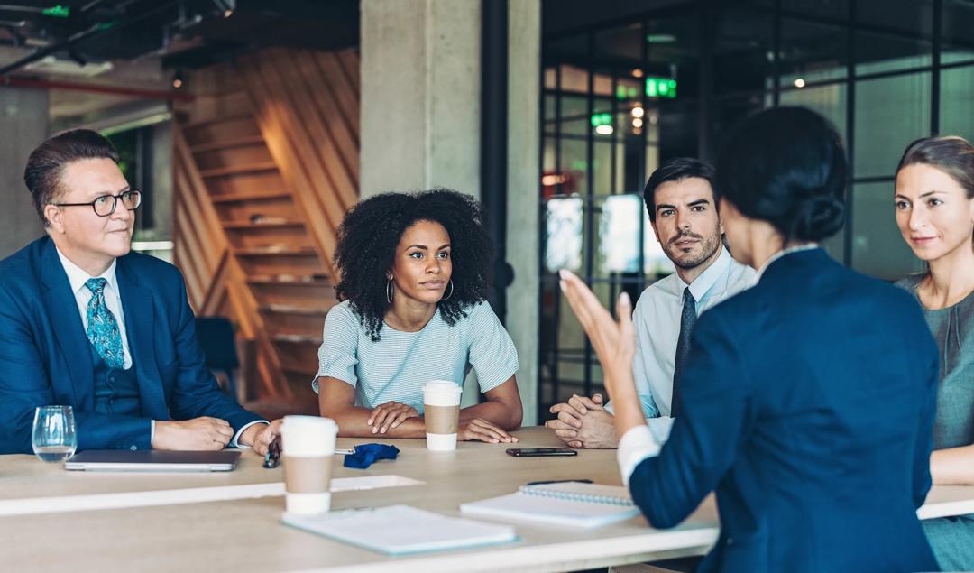 People sitting in together and talking at a meeting