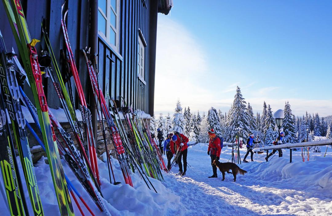 People putting their ski against a cabin