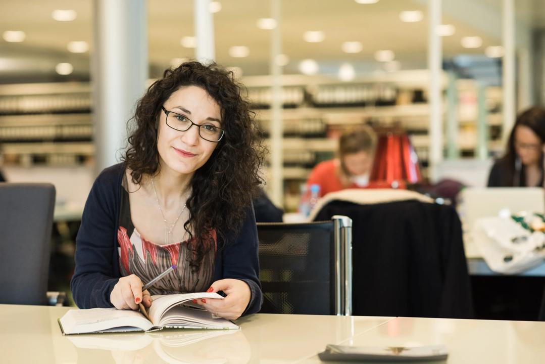 A woman with glasses sitting in the office