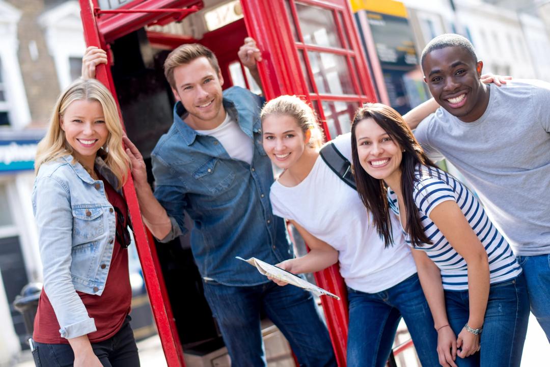 En gruppe studenter foran en telefonkiosk i London