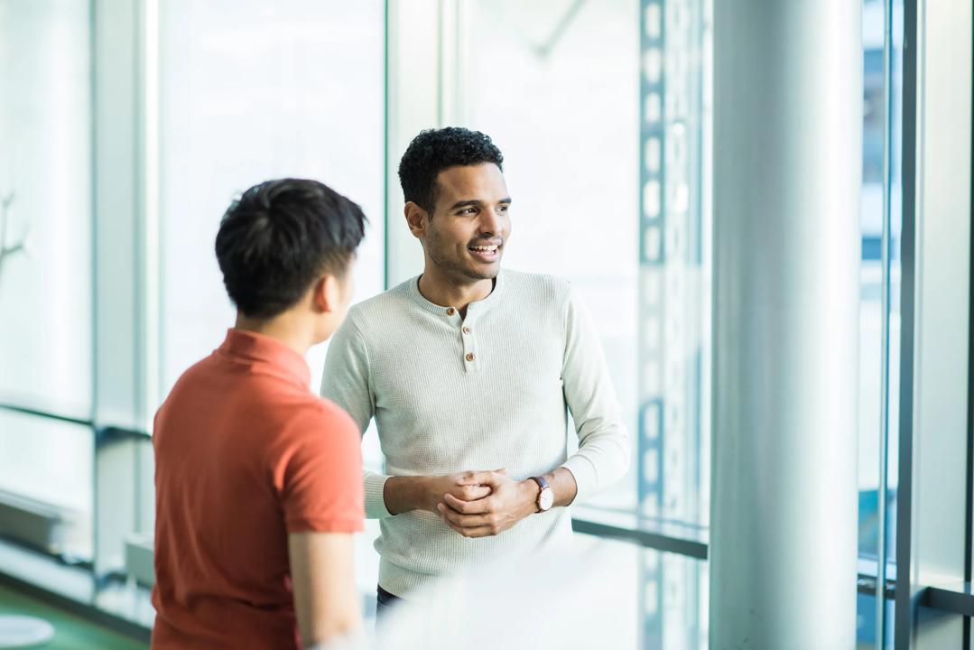 Two students talking with each other in the library