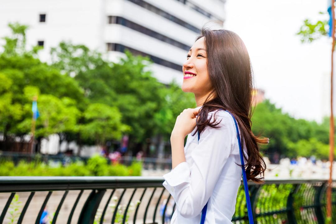 A woman smiling on a bridge